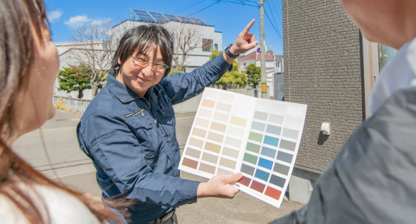 カラー見本を持ち、お客様へ提案しているスタッフ