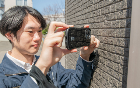 写真を撮り現地調査するスタッフ