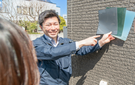 大判の色見本を外壁へあてて確認する様子
